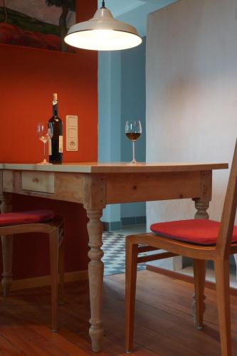 a table with two glasses of wine and a lamp at Ferienwohnung Grün und Aussichtsreich in Merzig