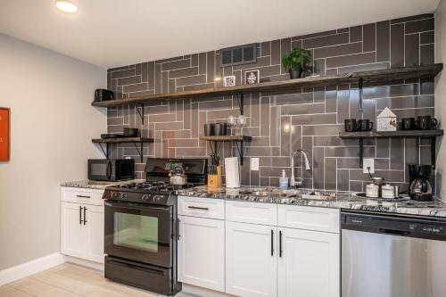 a kitchen with white cabinets and black appliances at ATL Downtown 2BR King Bed Free Parking LM1003 in Atlanta