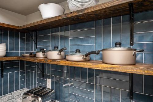 a row of pots and pans on a shelf in a kitchen at NEW ENTIRE PLACE Cozy 2B2B with King Bed SP1263 in Norcross