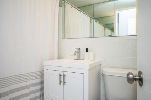 een witte badkamer met een wastafel en een spiegel bij ATL Downtown 2BR King Bed Free Parking LM1003 in Atlanta
