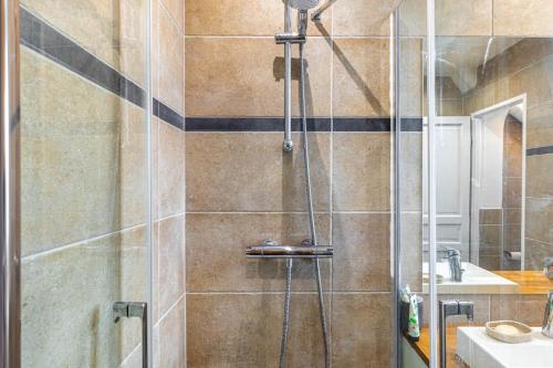 a bathroom with a shower with a glass door at GuestReady - Modern stay near Atelier des Lumières in Paris