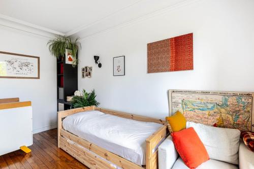 a bedroom with a bed and a couch at GuestReady - Modern stay near Atelier des Lumières in Paris