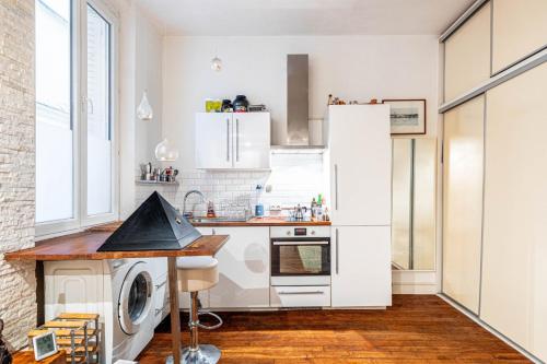 巴黎的住宿－GuestReady - Chic Studio Retreat by Sacré-Cœur，厨房配有白色橱柜、洗衣机和烘干机