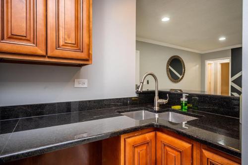 a kitchen with a sink and wooden cabinets at Downtown! 24h Concierge! Private Balcony! 11K in Atlanta