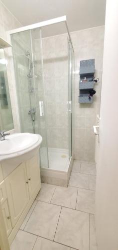 une salle de bain blanche avec une douche et un lavabo dans l'établissement L'escale à 500m des plages, à Antibes