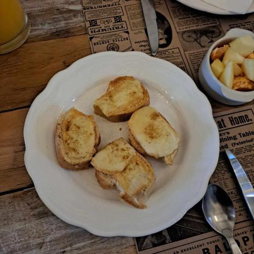 a white plate with slices of bread on a table at Au charme d'antan in Féron