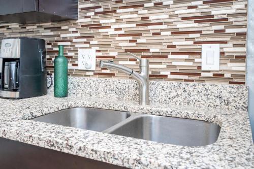 a kitchen sink with a green soap dispenser next to it at Downtown ! King bed 24 concierge! Onsite Parking LM903 in Atlanta