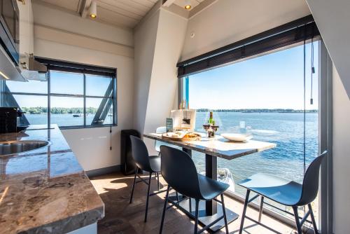 a kitchen with a table and chairs with a view of the water at Numa Amsterdam The Crane in Amsterdam