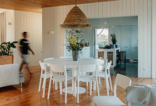 a white dining room with a white table and chairs at Casa 7 boxes - amazing villa with heated pool in Comporta