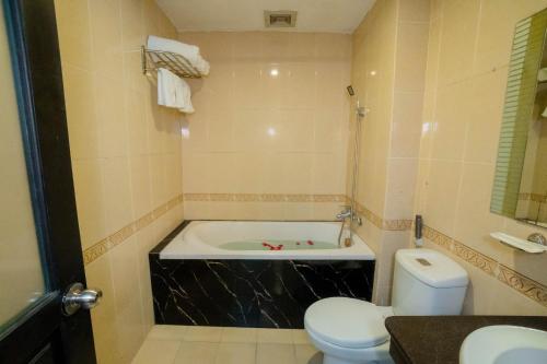 a bathroom with a bath tub and a toilet at Vina Center Hotel in Hue