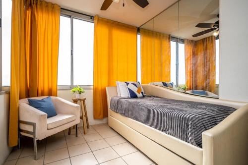 sypialnia z pomarańczowymi zasłonami, łóżkiem i krzesłem w obiekcie Heart ATL Downtown High Rise 2B2B Condo LM2206 w Atlancie