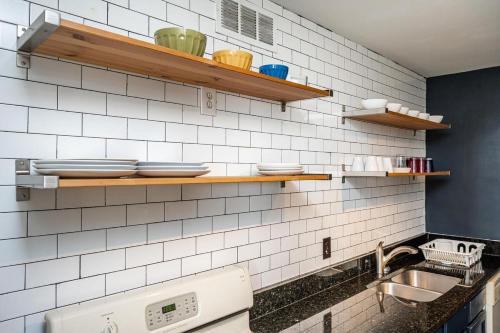 a kitchen with a sink and white tiled walls at Heart ATL Downtown High Rise 2B2B Condo LM2206 in Atlanta