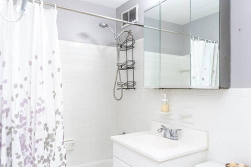 a white bathroom with a sink and a mirror at Downtown Atlanta Excellent View! Onsite Parking 1904 in Atlanta