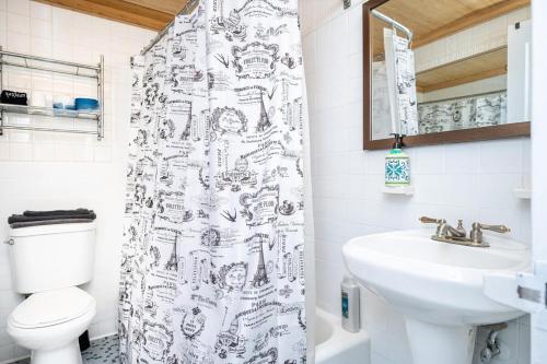 a bathroom with a shower curtain with a toilet and a sink at ATL Downtown Private Balcony 24h Concierge PT6F in Atlanta