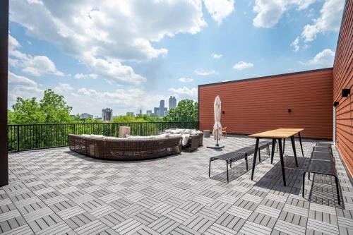 a patio with a table and a bench and a building at Downtown New Built Roof top balcony City View 525Pkwy in Atlanta
