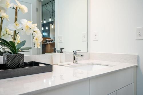 a white bathroom with a sink and a mirror at Downtown New Built Roof top balcony City View 525Pkwy408 in Atlanta