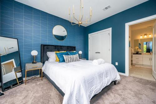 a blue bedroom with a large bed and a mirror at Downtown New Built Roof top balcony City View 525Pkwy408 in Atlanta