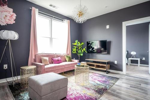 a living room with a pink couch and a tv at Downtown New-Built Roof-top balcony City View 525Pkwy in Atlanta