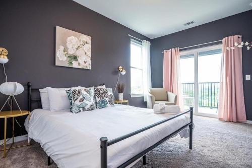 a bedroom with a large bed with blue walls at Downtown New-Built Roof-top balcony City View 525Pkwy in Atlanta