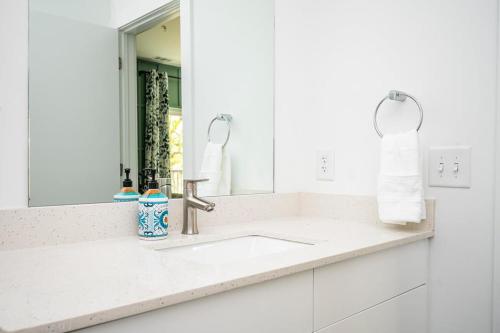 a white bathroom with a sink and a mirror at New Downtown ATL Condo Washer Dryer 542Blvd103 in Atlanta