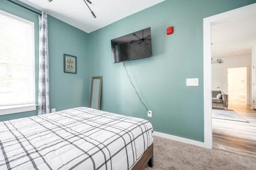 a bedroom with a bed and a flat screen tv on the wall at New Downtown ATL Condo Washer Dryer 542Blvd in Atlanta