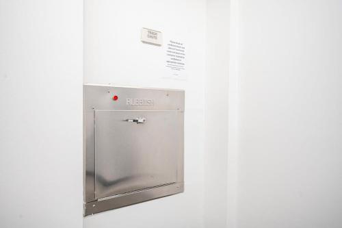 a metal cabinet with a door in a wall at New Downtown ATL Condo Washer Dryer 542Blvd in Atlanta