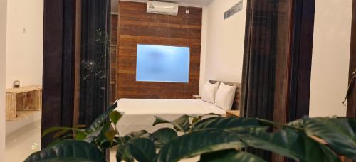 een kleine kamer met een bed en een spiegel bij Dream house teges jati in Ubud