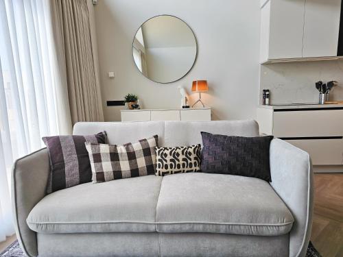 ドンブルグにあるVakantiewoning DO54 centrum Domburgのリビングルーム(ソファ、枕、鏡付)
