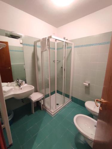 a bathroom with a shower and a toilet and a sink at Hotel Il Guscio in Grado