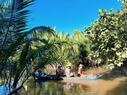 a group of people riding on a boat on a river at Hide Away Bungalows in Ben Tre City in Ấp Phú Hòa (3)