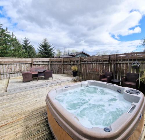 bañera de hidromasaje en una terraza con mesa y sillas en Torridon 1 with Private Hot Tub - Fife - Loch Leven - Lomond Hills- Pet Friendly, en Kelty