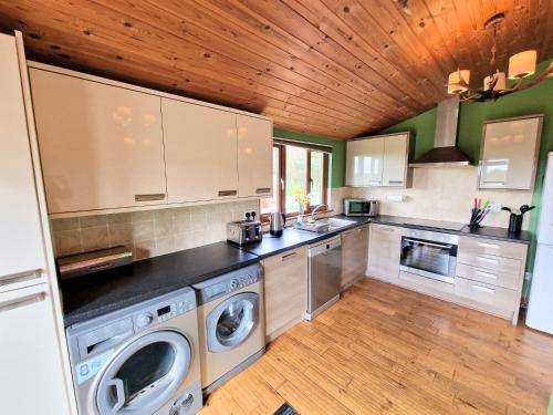 una cocina con lavadora y secadora. en Torridon 1 with Private Hot Tub - Fife - Loch Leven - Lomond Hills- Pet Friendly, en Kelty