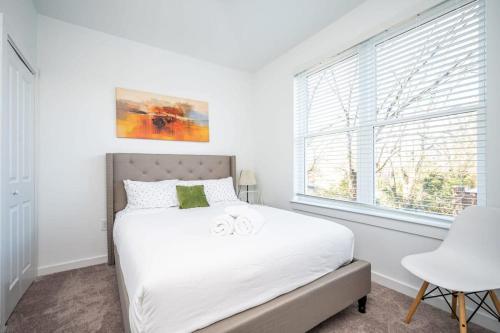 a white bedroom with a bed and a window at Luxe 1BR w Balcony in Downtown 542Blvd206 in Atlanta