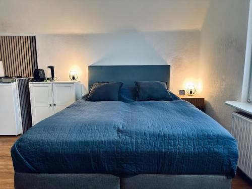 um quarto com uma cama azul e um cobertor azul em FeWo Burgnest em Bad Bentheim