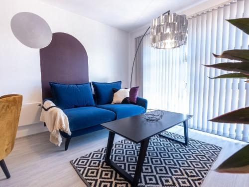 sala de estar con sofá azul y mesa en Pristine 1 and 2 bedroom apartments near business district by Belvilla, en Birmingham