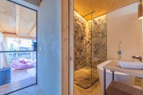 a bathroom with a tub and a glass shower at Casa CORTIJO con piscina privada in Tarifa
