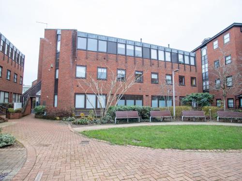 a brick building with benches in front of it at Pembroke House Apartments Exeter For Families Business Relocation Free Parking in Exeter