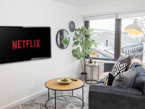a living room with a tv with the netflix sign on the wall at Pembroke House Apartments Exeter For Families Business Relocation Free Parking in Exeter