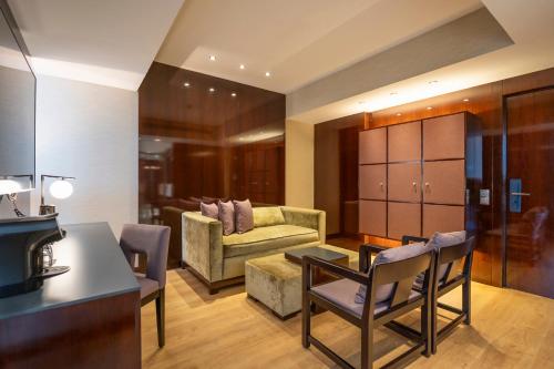 a living room with a couch and a table at Hyatt Regency Barcelona Tower in Hospitalet de Llobregat