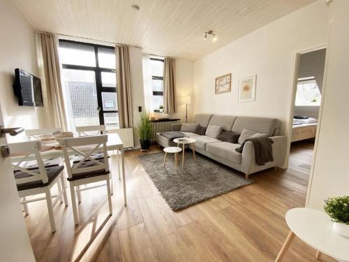 a living room with a couch and a table at Ferien im Wangerland - Haus Wiesenweg - Ferienwohnung 1 1OG in Horumersiel