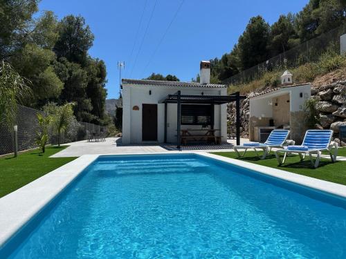 a villa with a swimming pool in front of a house at La Casona del Pinar Swiming Pool in Alhaurín de la Torre