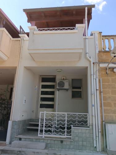 a white house with stairs and a balcony at Casa Beatrice in Specchiolla 