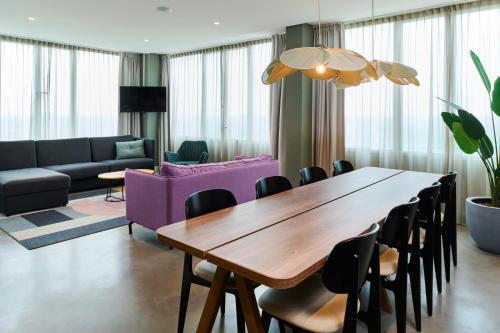 a living room with a wooden table and chairs at Cityden BoLo District in Amsterdam