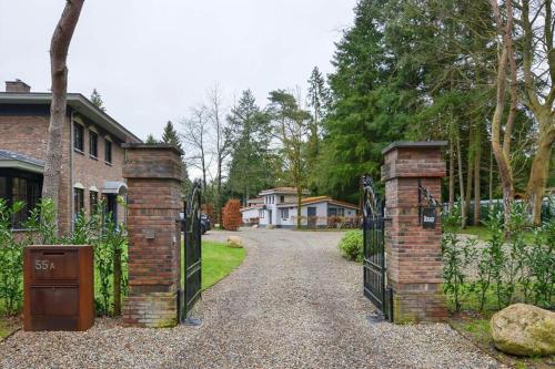 an entrance to a house with a gate and a driveway at Casa do Cervo, Boshof 6 Luxe met overdekt terras in Ermelo