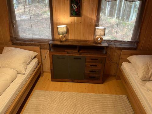 a room with two beds and a desk with two candles at Urige idyllische Hütte mit Sauna in Grainet