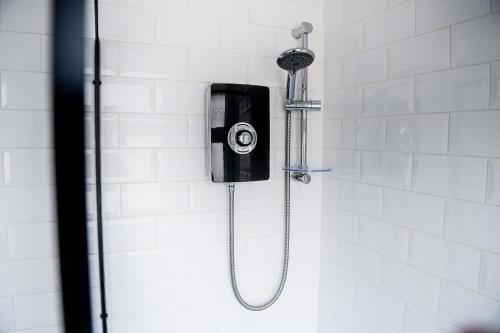 a shower with a shower head on a wall at Poppy's Place - Manningham Road in Liverpool