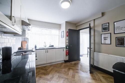 a kitchen with white cabinets and a counter top at Poppy's Place - Manningham Road in Liverpool