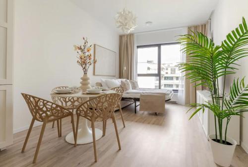 Una sala de estar con una mesa y sillas y un sofá. en Magnolie Suite Presidential Garden Free Parking, en Bratislava