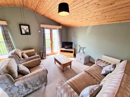 a living room with two couches and a tv at Lomond 2 with Private Hot Tub - Fife - Loch Leven - Lomond Hills in Kelty