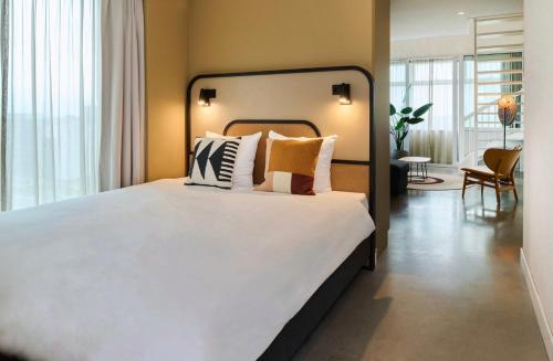- une chambre dotée d'un grand lit avec des draps et des oreillers blancs dans l'établissement Cityden BoLo District, à Amsterdam